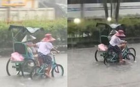 Xúc động em nhỏ còng lưng đạp xe, đẩy xe người khuyết tật khi mưa to, đường ngập