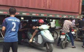 Bất chấp nguy hiểm, người dân thi nhau chui gầm container chắn ngang giữa đường để lưu thông