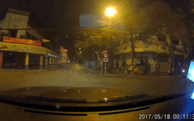 Vượt đèn đỏ trong đêm, xe máy nằm gọn dưới gầm ô tô