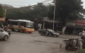 Người đàn ông đứng giữa phố Hà Nội, dùng búa đập vào các xe ô tô chạy qua