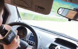Kẹp 3 ngón tay vào vô-lăng, người phụ nữ cắm mặt vào điện thoại, say sưa hát karaoke khi đang lái xe với tốc độ cao
