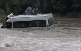 CLIP: Xe khách "lao nhầm" vào dòng nước lũ chảy xiết, tài xế và khách trèo lên nóc xe bất lực