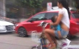 Bà mẹ trẻ cho con bú khi đang đi xe đạp điện